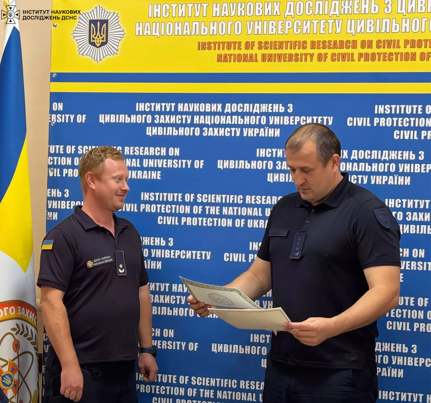 Начальник Інституту наукових досліджень ДСНС вручає диплом науковцю.